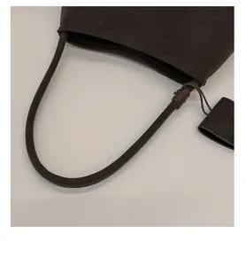 Detail of round comfortable handle and matte brown suede texture on vintage French bag