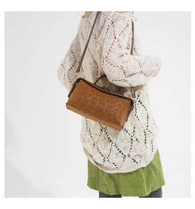 Brown leopard print shoulder bag styled with an elegant beige sweater and green skirt