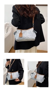 Détail du sac à bandoulière gris avec bordure en cuir, poche latérale et sangle réglable
