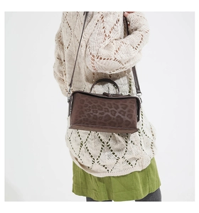 Detail view of the structured animal print handbag with a refined leopard pattern
