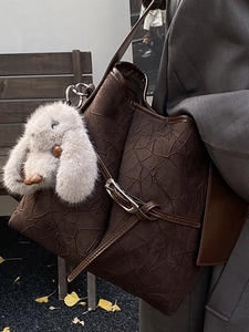 Chic dark brown pleated bucket bag with plush rabbit charm and silver metal buckle