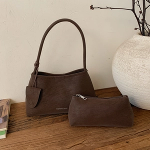 Close-up of retro dark brown suede shoulder bag with matching rectangular pouch set