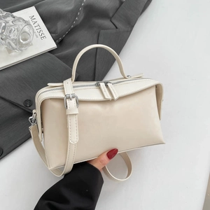 Detail of minimalist cream leather Boston bag with silver zippers and top handle