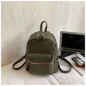 Detail view of olive green faux leather mini backpack with contrast stitching and gold zippers