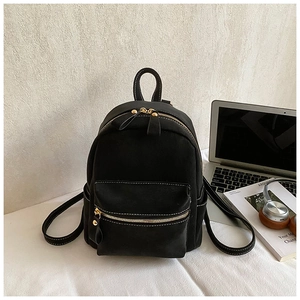 Detail of black mini backpack with contrast stitching, laptop, and leisure accessories