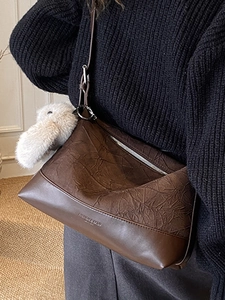 Minimalist large brown dumpling bag for women with plush rabbit charm and silver zipper