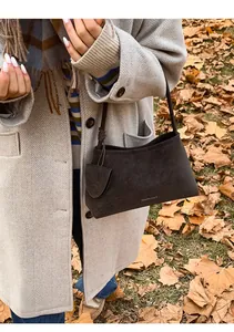 Detail of dark brown suede shoulder bag with a vintage trapezoid shape and minimalist strap