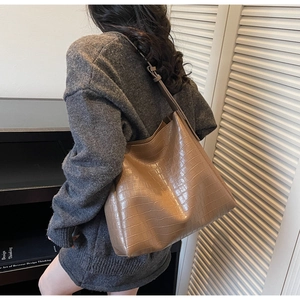 Detail view of brown crocodile texture hobo bag showing material drape and large capacity