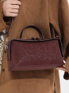 Deep burgundy leopard print box bag with top handle and adjustable leather strap