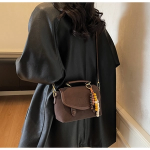 Brown retro leather crossbody bag with wooden bead charm and golden buckle hardware