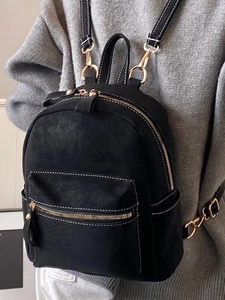 Minimalist black mini backpack with white contrast stitching and gold metal hardware