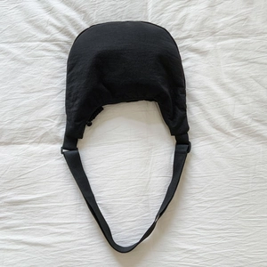 Detailed top view of a black crescent nylon crossbody bag with adjustable wide strap