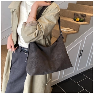 Detail of dark brown faux suede tote bag with cross stitching on high-quality material