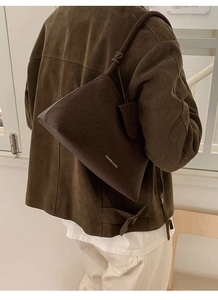 Close-up of dark brown suede leather shoulder bag with fine texture and fashion logo