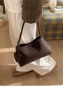 Detailed macro view of dark coffee suede tote bag with fine stitching and fashion lettering