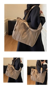 Detail view of khaki canvas tote bag with wide shoulder strap in minimalist indoor setting