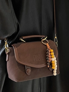 Vintage dark brown crossbody bag with top handle and decorative beaded pendant detail