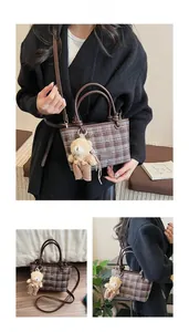 Détails du sac seau marron à carreaux avec pendentif ours et motifs de nœuds blancs