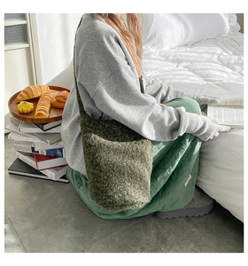 Détail du sac cabas en peluche vert foncé à l'épaule, montrant la texture douce en polaire