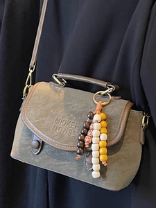 Vintage green crossbody bag with top handle and colorful bead tassel in a stylish look
