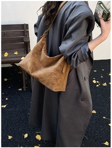 Detail of premium brown suede tote bag featuring fine stitching in a fall setting