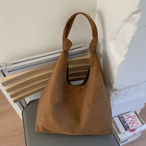 Macro shot of large brown suede tote bag texture and soft integrated handle design