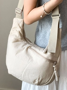 Minimalist beige crescent tote bag with adjustable wide strap for daily winter commute
