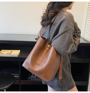 Detail of vintage brown suede tote bag with golden twist lock and adjustable strap