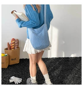 Gros plan d'un sac cabas en polaire bleue avec détail floral sur un mannequin en extérieur