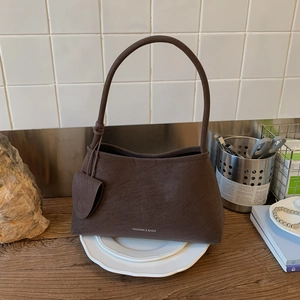 Close-up of vintage brown suede shoulder bag texture with detachable mini pouch detail