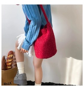 Détail du sac seau en peluche rouge avec texture laineuse douce et bandoulière assortie