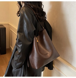 Detail view of the brown suede-texture tote bag featuring minimalist fashion typography