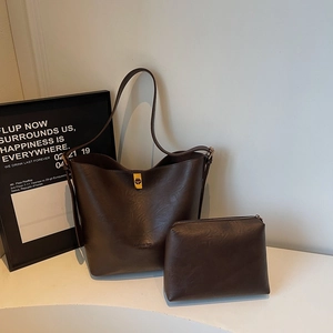 Detail view of deep brown bucket bag set with inner pouch and gold twist lock clasp
