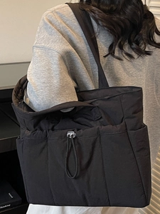 Minimalist black quilted tote bag for women with drawstring detail for daily travel