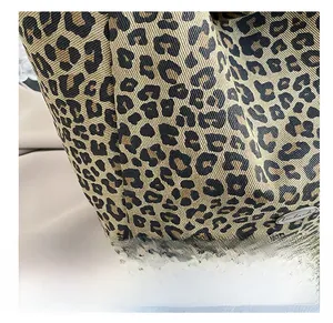 Detail of leopard print canvas fabric with a metal Handmade badge on the tote bag