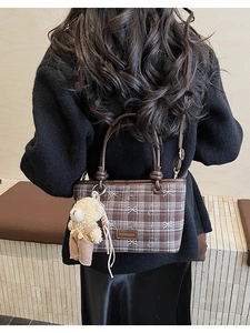 Détail du sac à main à carreaux marron avec broderie ours et un charm ours en peluche