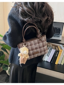 Détail du sac cabas à carreaux marron avec broderie de nœuds et pendentif ours en peluche