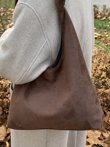 Brown large capacity suede tote bag for women shown in an outdoor autumn setting