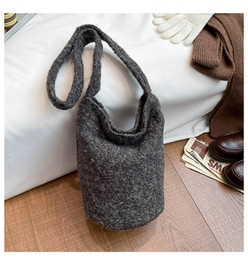 Détail de la texture d'un sac cabas en tricot gris foncé avec accessoires mode