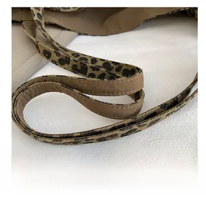 Detail of a leopard print canvas tote strap with reinforced double stitching