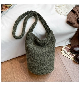 Détail de la texture du sac fourre-tout en tricot vert mousse en fil bouclé doux