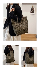 Detail view of large leopard print canvas tote bag with metal logo and shoulder straps