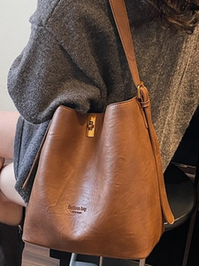 Vintage brown faux suede bucket bag with adjustable strap and metal buckle clasp
