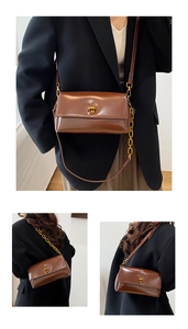 Détail du sac bandoulière en cuir verni marron foncé avec fermoir doré et chaîne