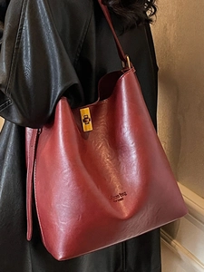 Burgundy suede leather tote bag with gold buckle and spacious bucket design