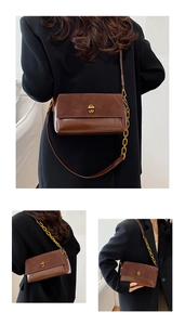 Détail du sac carré marron avec texture de cuir mat et bandoulière en chaîne dorée chic