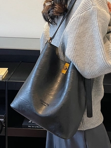Chic black oversized suede bucket bag for women with bronze metal buckle and strap