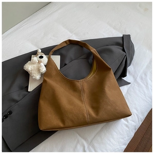 Detail of brown tote bag with white contrast stitching and soft matte texture