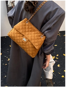 Détail du sac matelassé caramel avec fermoir tournant argenté et feuilles de ginkgo