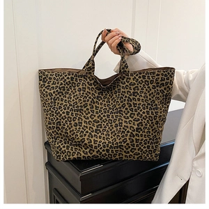 Detail view of large leopard print tote bag with thick strap handle and canvas texture